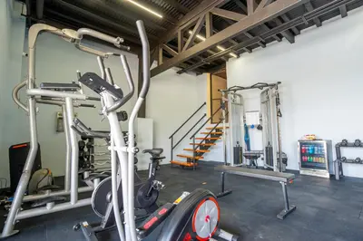 a gym with several tread machines and a treadmill at La Parada House in Heredia