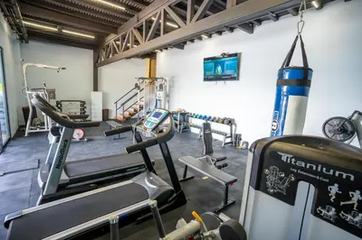 a gym with several treadmills and machines at La Parada House in Heredia