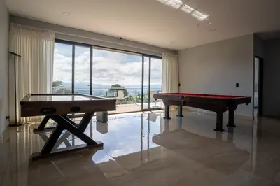 a room with a pool table and a large window at La Parada House in Heredia