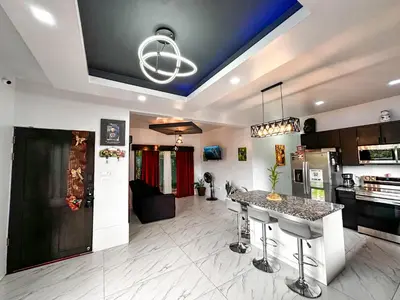 a kitchen and living room with a table in the middle at MaBri Arenal Home in Agua Azul