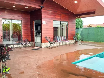 a patio with chairs and a table and a swimming pool at MaBri Arenal Home in Agua Azul