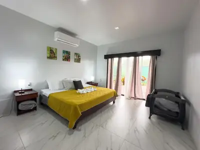 a bedroom with a bed and a large window at MaBri Arenal Home in Agua Azul