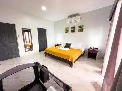 a bedroom with a bed with a yellow blanket at MaBri Arenal Home in Agua Azul