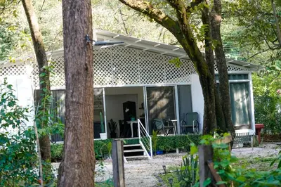 a white house with a porch and trees at Casa Guanabana in Nicoya