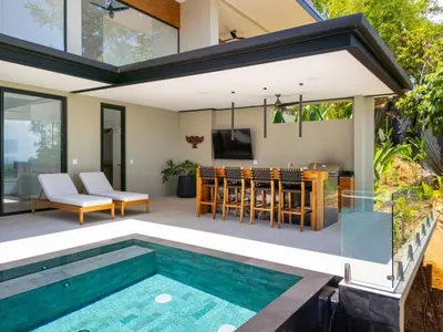 an outdoor entertaining area with a pool and a house at Villa Serenidad in Uvita