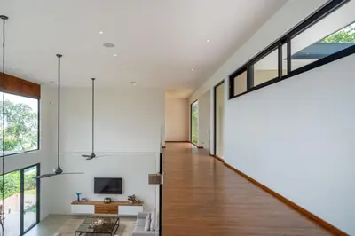 a hallway of a house with white walls and large windows at Villa Serenidad in Uvita