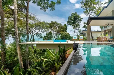 an exterior view of a house with a swimming pool and trees at Villa Serenidad in Uvita