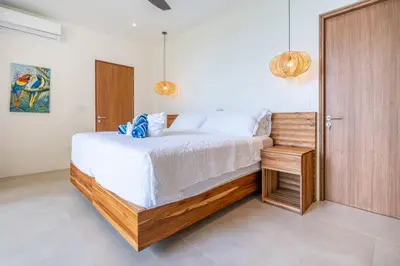 a bedroom with a large bed and a wooden door at Villa Serenidad in Uvita
