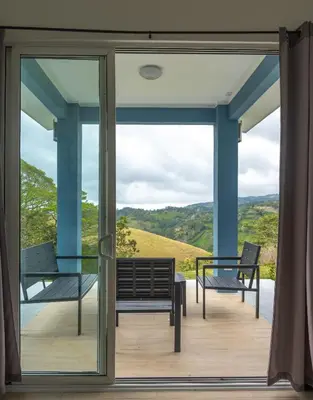 a glass door leading to a deck with benches at Casa Grano de Oro Cozy Home in Monteverde in Turín