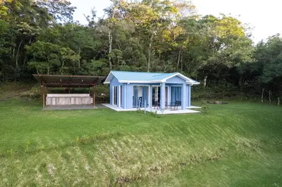 a small blue house in a field of grass at Casa Grano de Oro Cozy Home in Monteverde in Turín