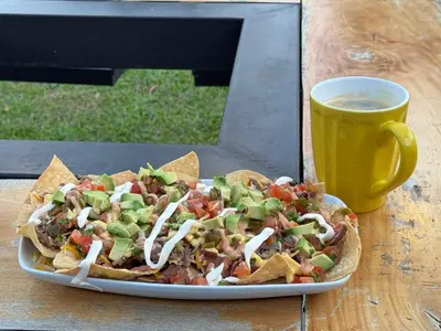a plate of nachos next to a cup of coffee at Casa Grano de Oro Cozy Home in Monteverde in Turín