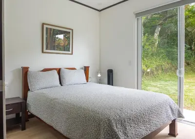 a bedroom with a bed and a large window at Casa Grano de Oro Cozy Home in Monteverde in Turín