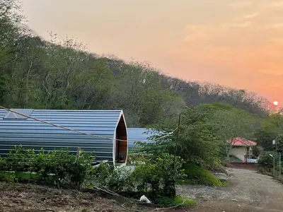 a blue building with a hill in the background at Villas alice in Huacas