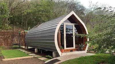 a tiny house with a gambrel roof and a window at Villas alice in Huacas