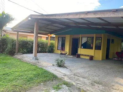 a yellow house with a bench in front of it at Casa Vacacional fachento house in Parrita