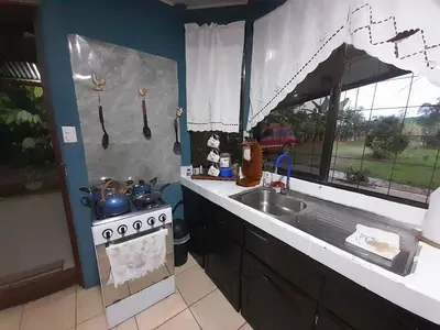 a kitchen with a stove and a sink and a window at Casa Vacacional fachento house in Parrita