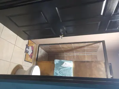 a bathroom with a toilet and a mirror at Casa Vacacional fachento house in Parrita