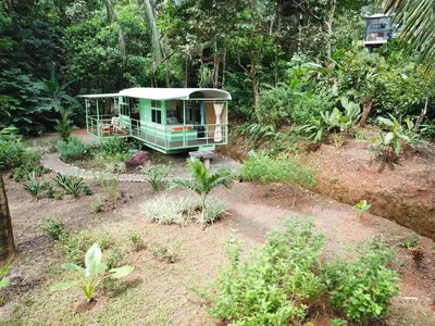 a small house in the middle of a garden at Jungle Bus, 5 min drive to PlayaLinda, 15 to Dominical, Wifi Starlink in Quepos