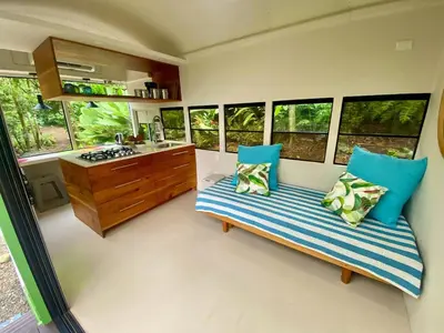 a room with two beds and a kitchen with windows at Jungle Bus, 5 min drive to PlayaLinda, 15 to Dominical, Wifi Starlink in Quepos