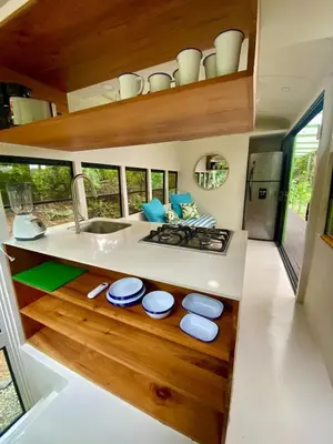 a kitchen with a sink and a counter with blue stools at Jungle Bus, 5 min drive to PlayaLinda, 15 to Dominical, Wifi Starlink in Quepos