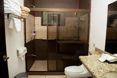 a bathroom with a shower with a toilet and a sink at Papagayo Hotel y Villas in Playa Panama