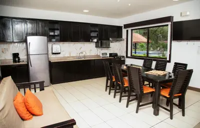 a kitchen with a table and chairs and a refrigerator at Papagayo Hotel y Villas in Playa Panama