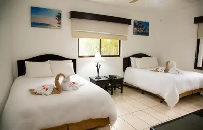 two beds in a room with two swans on them at Papagayo Hotel y Villas in Playa Panama