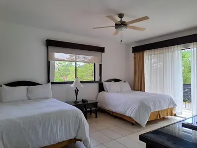 a bedroom with two beds and a ceiling fan at Papagayo Hotel y Villas in Playa Panama