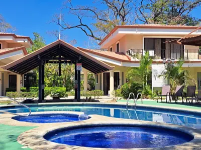 a swimming pool in front of a house at Papagayo Hotel y Villas in Playa Panama