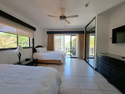 a bedroom with two beds and a ceiling fan at Papagayo Hotel y Villas in Playa Panama