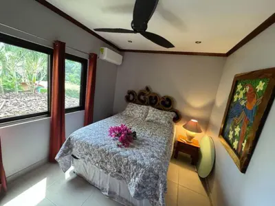 a bedroom with a bed with purple flowers on it at Condominio Punta Plata in Playa Flamingo