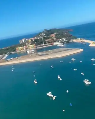 a group of boats in the water near an island at Condominio Punta Plata in Playa Flamingo