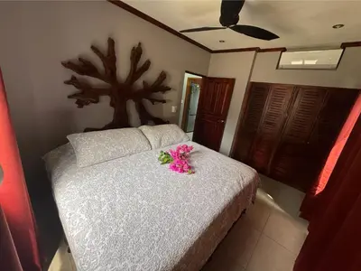 a bedroom with a bed with pink flowers on it at Condominio Punta Plata in Playa Flamingo