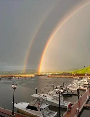 a rainbow over a marina with boats in the water at Condominio Punta Plata in Playa Flamingo