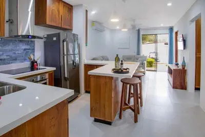 a kitchen with a island in the middle of it at Minimalist Condo with a Beautiful New Design, Bound Patio, and Shared Community Pool in Coco