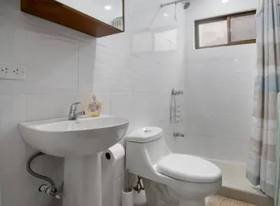 a white bathroom with a sink and a toilet at Minimalist Condo with a Beautiful New Design, Bound Patio, and Shared Community Pool in Coco