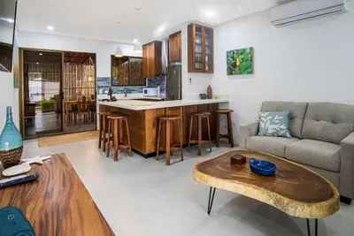 a kitchen and living room with a couch and a table at Minimalist Condo with a Beautiful New Design, Bound Patio, and Shared Community Pool in Coco