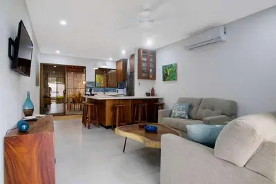 a living room with a couch and a table at Minimalist Condo with a Beautiful New Design, Bound Patio, and Shared Community Pool in Coco