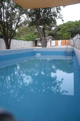 a swimming pool with blue water in a yard at Nanay's House in Venado