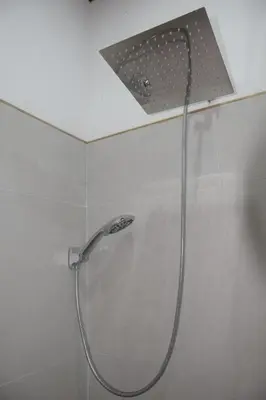 a shower with a shower head in a bathroom at Nanay's House in Venado