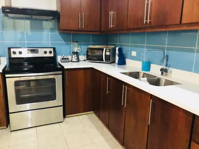 a kitchen with a stove microwave and a sink at La buena vida ocean Tamarindo in Libertad