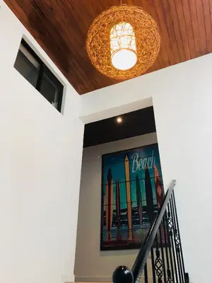 a chandelier and a painting of surfboards on a wall at La buena vida ocean Tamarindo in Libertad