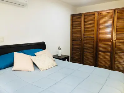 a bedroom with a large bed and wooden cabinets at La buena vida ocean Tamarindo in Libertad