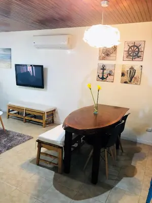 a dining room with a table and chairs and a tv at La buena vida ocean Tamarindo in Libertad