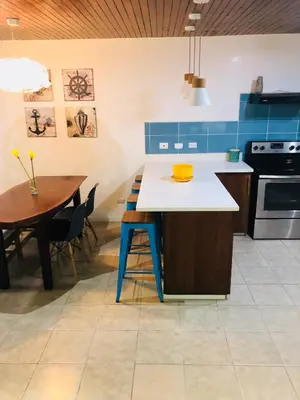 a kitchen with a blue and white counter and a table at La buena vida ocean Tamarindo in Libertad