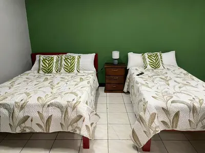 two beds sitting next to each other in a bedroom at la casona rio in Alajuela City