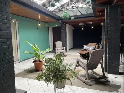 a patio with two chairs and a table and plants at la casona rio in Alajuela City