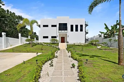 a white house with a pathway in front of it at Casa Corales Dreams 1 in Playa Flamingo