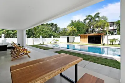 an open living room with a wooden table and a swimming pool at Casa Corales Dreams 1 in Playa Flamingo