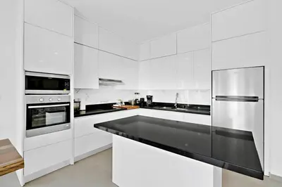 a kitchen with white cabinets and a stainless steel refrigerator at Casa Corales Dreams 1 in Playa Flamingo